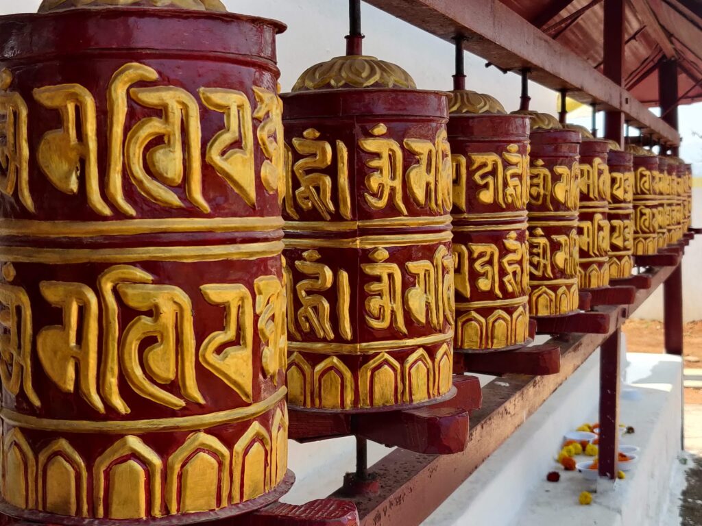 Row of sacred Buddhist prayer wheels at Chandragiri monastery
